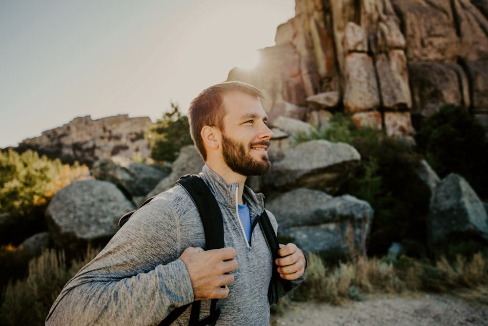 man on a hike smiling
