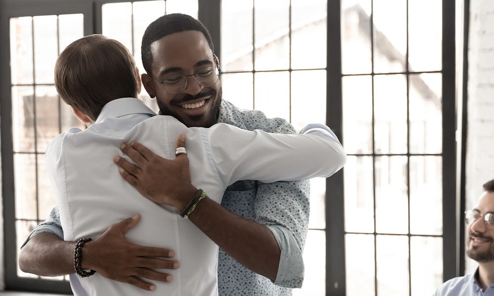 two men hugging during 12 step meeting