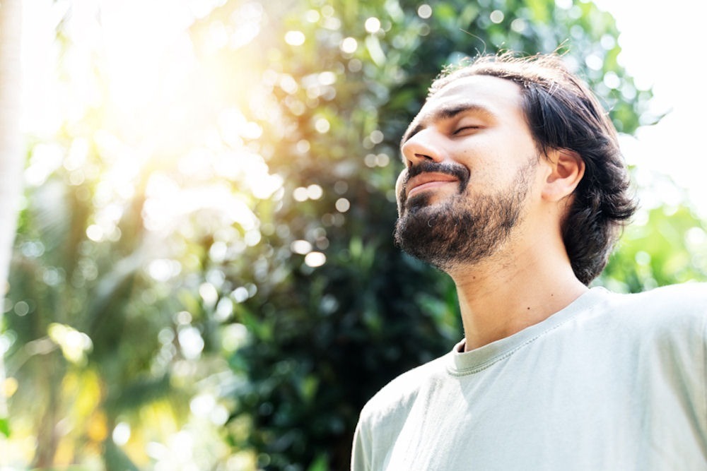 smiling man with his face toward the sun