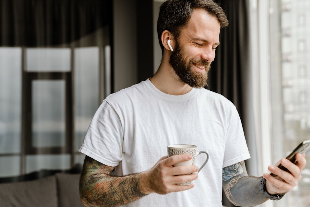 man holding a cup and talking on his phone