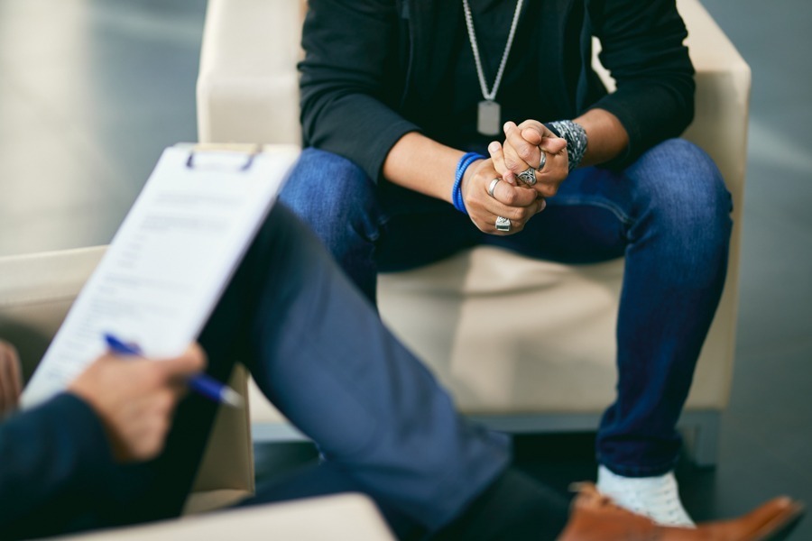 a man with addiction sitting while attending rehab