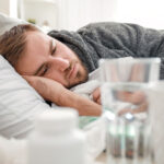 man in bed wondering how long his alcohol poisoning will last