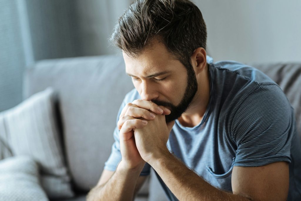 Man with social anxiety considers using alcohol as a coping mechanism before a social outing.