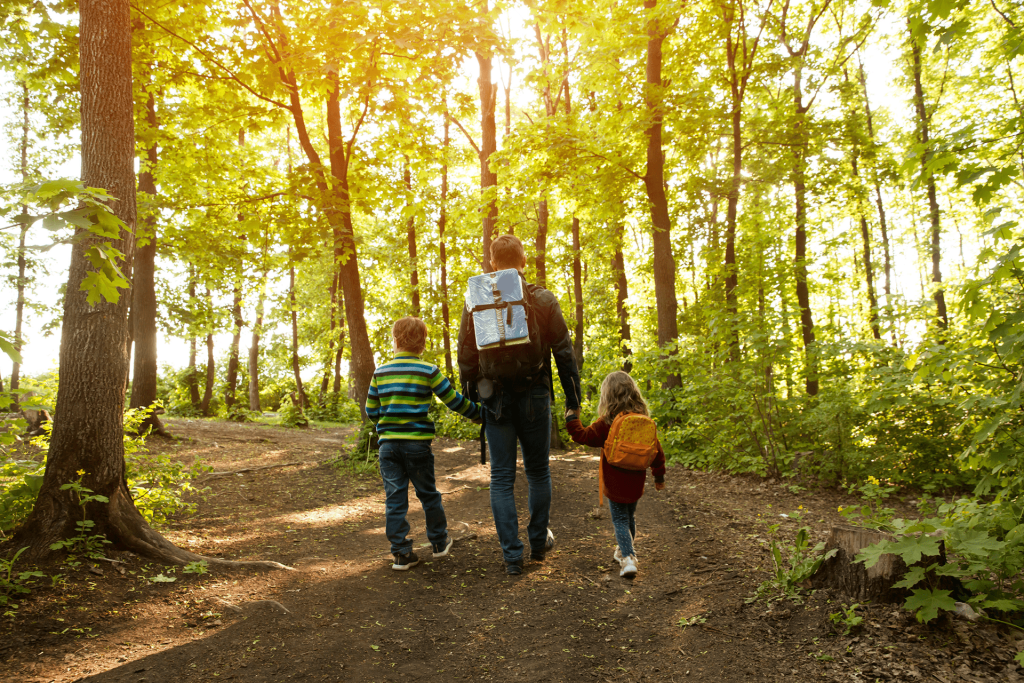 Father walking with his young son through the woods, representing breaking generational addiction and building a healthier future.